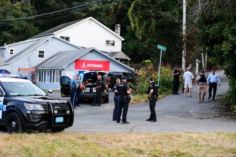 State Police and local law enforcement officers gather along Route 5 near East Street in Easthampton on Friday afternoon as they search for a man who allegedly hit and dragged a state trooper on nearby Interstate 91. A State Police K-9 unit found the Greenfield man after a two-and-half hour search.