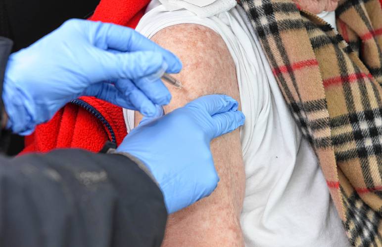 Jenny Potee, public health nurse for the town of New Salem, administers a COVID-19 vaccine in the parking lot of Ralph C. Mahar Regional School in Orange.