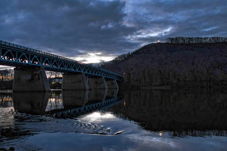 The holiday lights atop Mount Sugarloaf are reflected in the Connecticut River as seen from Sunderland.