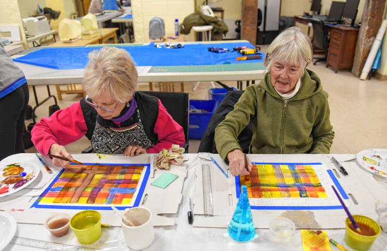 From left, Greenfield resident Sandy Kosterman and Erving resident Sue Sharbaugh learn how to blend colors using acrylic paints before tackling subjects in an art class at the Bernardston Senior Center taught by Dianne  Cornwell on Tuesday.