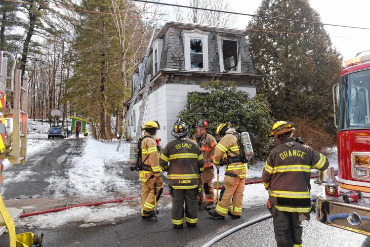 Firefighters outside a two-story, gambrel-style home that was the scene of a fire Wednesday morning on Mechanic Street in Orange.