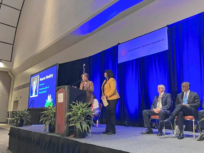 Gov. Maura Healey delivers remarks during the Massachusetts Municipal Association’s annual meeting at the Hynes Convention Center on Friday. She’s joined on stage by Lt. Gov. Kim Driscoll.