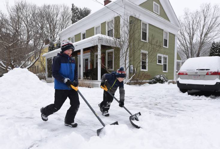 Friends Liam Walker, then 13, and Aksel Whitsett, then 8, shovel the Walker family’s driveway in Shelburne Falls in February 2022. As snow blankets the region on Tuesday, Baystate Health officials have some tips for residents to ensure safe shoveling.