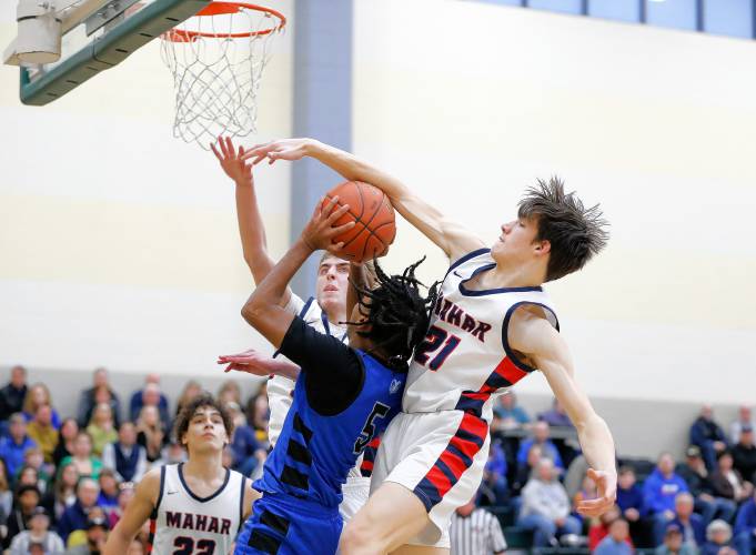 Mahar’s Marshall Ames (21) blocks a shot attempt from Granby’s Gavier Fernandez (5) in the third quarter of the Western Mass. Class C boys basketball championship Saturday at Holyoke Community College.