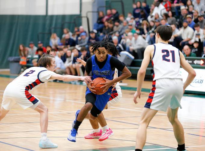 Granby’s Gavier Fernandez (5) drives through the lane past Mahar’s Morgan Softic (2) in the fourth quarter of the Western Mass. Class C boys basketball championship Saturday at Holyoke Community College.