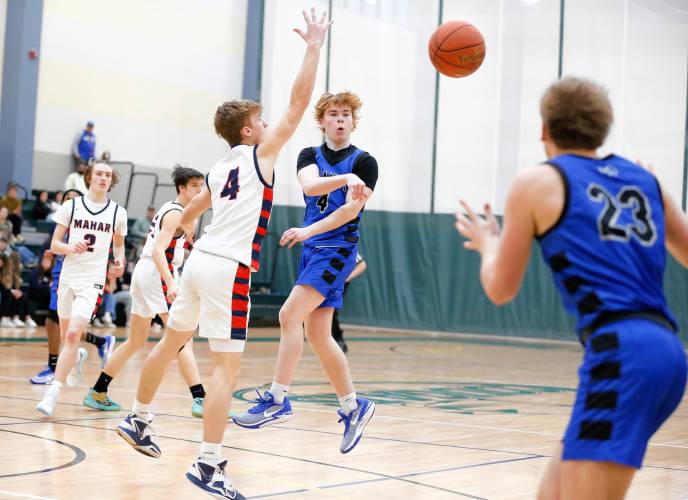 Granby’s Colin Murdock (4) dishes a past to Cody White (23) past Mahar’s Lucas Isrow (4) in the third quarter of the Western Mass. Class C boys basketball championship Saturday at Holyoke Community College.