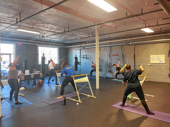 Common Ground Fitness Center instructors Erica Burns (left in purple) and Emma Marscher (right in black) lead participants through a Barre fitness class on Sunday to raise money for  Big Brothers Big Sisters of Western Mass.