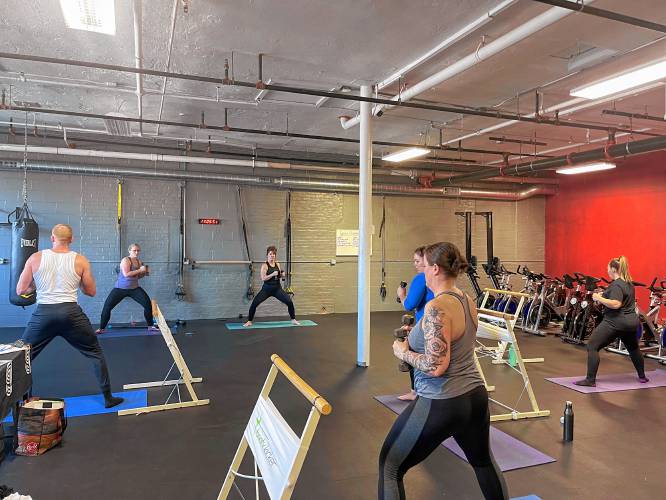 Common Ground Fitness Center instructors Erica Burns (left in purple) and Emma Marscher (right in black) lead participants through a Barre fitness class on Sunday to raise money for  Big Brothers Big Sisters of Western Mass.