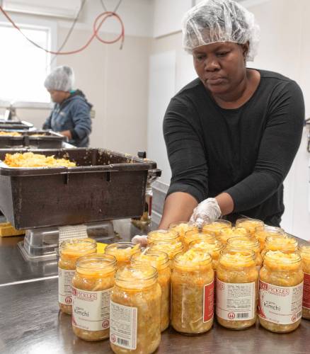 Katie Desi, front, and Marie Maude Joseph package kimchi at Real Pickles in Greenfield.