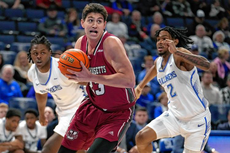 Massachusetts' Josh Cohen (23) heads to the basket as Saint Louis' Bradley Ezewiro, left, and Larry Hughes II (2) defend earlier this season in St. Louis.