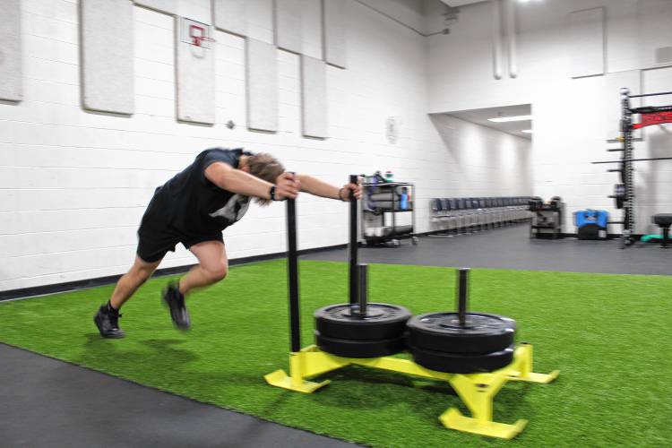 Pioneer Valley Regional School junior Jerad Goulston pushes the sled in the school’s newly renovated auxiliary gym.