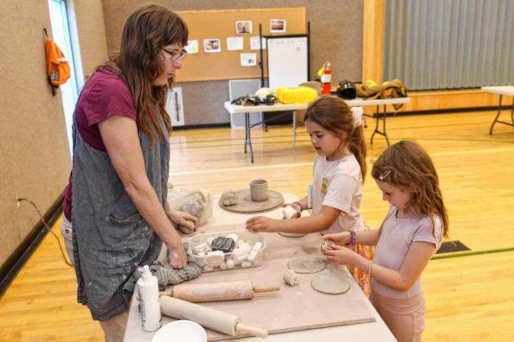 Potter Molly Cantor talks about her job with Rowe Elementary School first graders Riley Shattuck and Ayla Findlay at “That’s a Cool Job” Day on Wednesday.