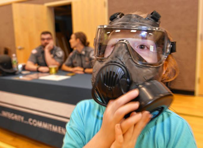 Preschooler Ronan Tanner tries on a gas mask from the Franklin County Sheriff’s Office at Rowe Elementary School for “That’s a Cool Job” Day on Wednesday.