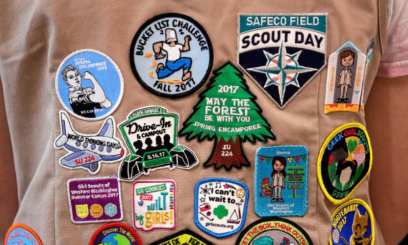 In this June 18, 2018, file photo, patches cover the back of a Girl Scout’s vest at a demonstration of some of their activities in Seattle.