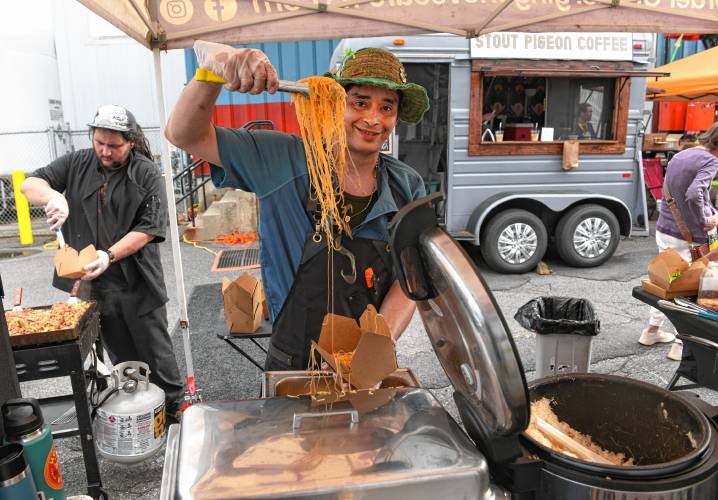 Xavier Garcia of Ginger Love Cafe serves up noodles with vegetables and chicken with rice at the Franklin County Community Development Corporation’s 45th anniversary block party in Greenfield on Thursday.