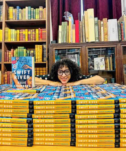 Essie Chambers, from Greenfield, poses next to her debut book “Swift River” at the Strand Book Store in New York City.