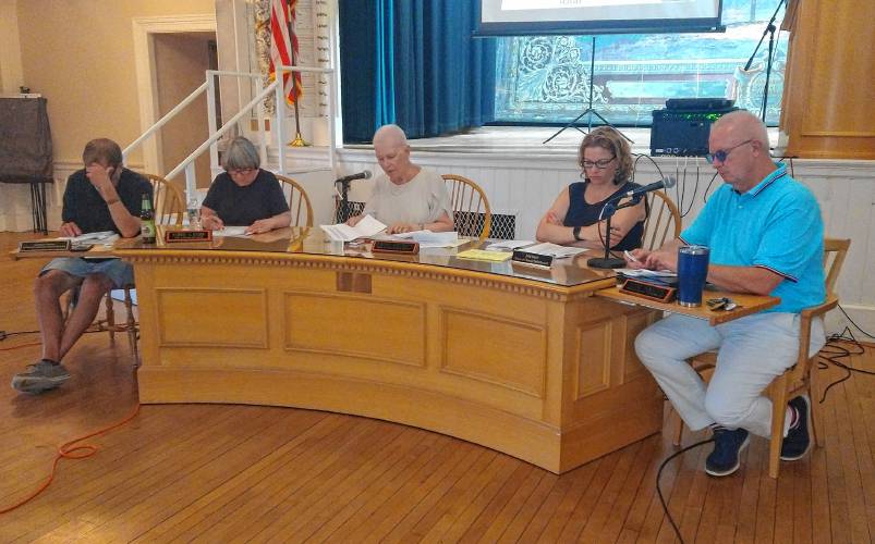 Selectboard Clerk Andrew Smith, Vice Chair Pat Lussier, member Jane Peirce, member Julie Davis and Chair Tom Smith sit in the Ruth B. Smith Auditorium inside Orange Town Hall on Monday for Special and Annual Town Meetings.