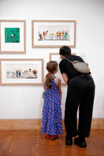 Emily DeMartino and her daughter Lyra, 6, check out some of the artwork in “Fuzuê! Invention & Imagination in the Art of Roger Mello,” the new exhibit at the Eric Carle Museum.