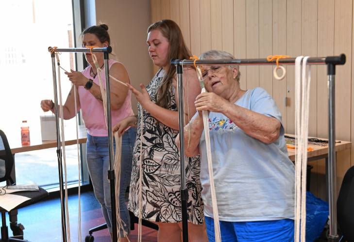 Participants separate strands for the next knot in a macrame class hosted by The Roundhouse Craft Series in the Greenfield Public Library.