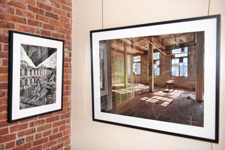 Photographs of old mill buildings by Leyden native Joe Wallace are on display in the Great Hall at the Great Falls Discovery Center in Turners Falls.