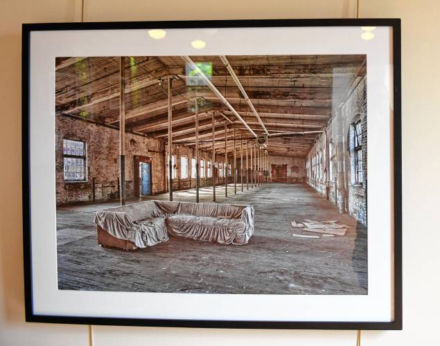 Photographs of old mill buildings by Leyden native Joe Wallace are on display in the Great Hall at the Great Falls Discovery Center in Turners Falls.