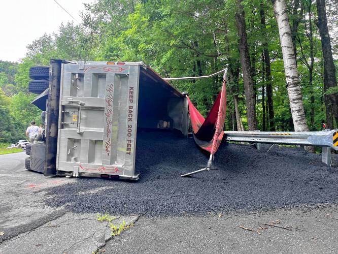 A dump truck rolled over and spilled its load of asphalt onto East Hawley Road in Hawley on Wednesday.