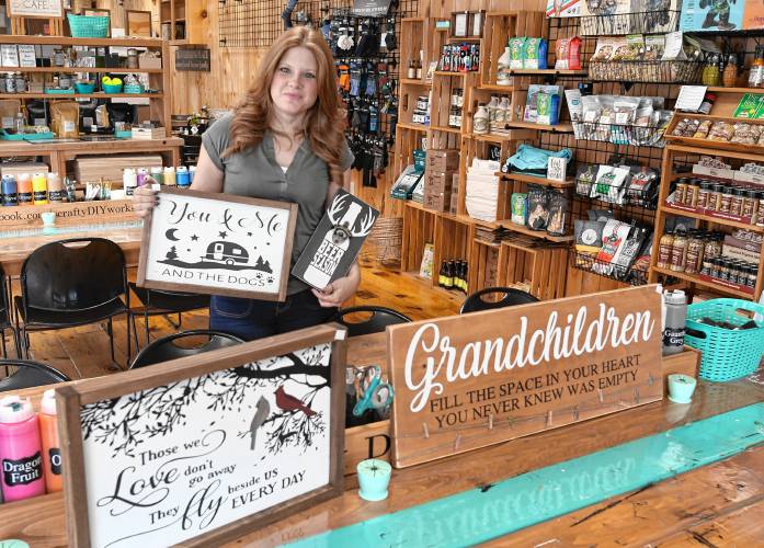 Stephanie Cook with examples of custom signs you can make at Scrafty DIY Workshop in Orange.