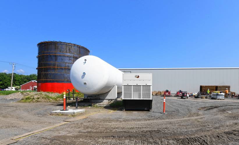 A large hot water storage tank being built next to a large propane tank with a generator at new facilities being constructed at Nourse Farms in Whately.