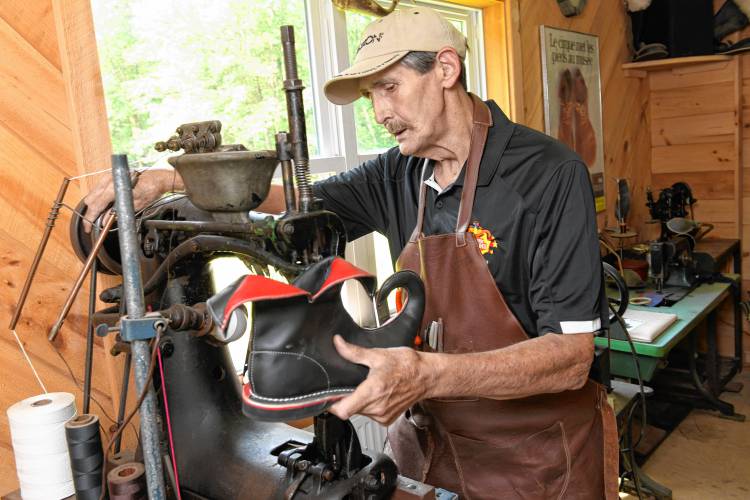 Gary Amiro uses a leather sewing machine to assemble his eclectic shoes of Jolly Walkers Clown Shoes in Wendell.