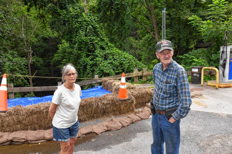 Helen and Robert Baker of Baker’s Country Store stand in what is left of their parking lot. Recent heavy rains eroded the embankment to the South River damaging the lot and septic system and forcing them to remove fuel from their underground tanks as a precaution.