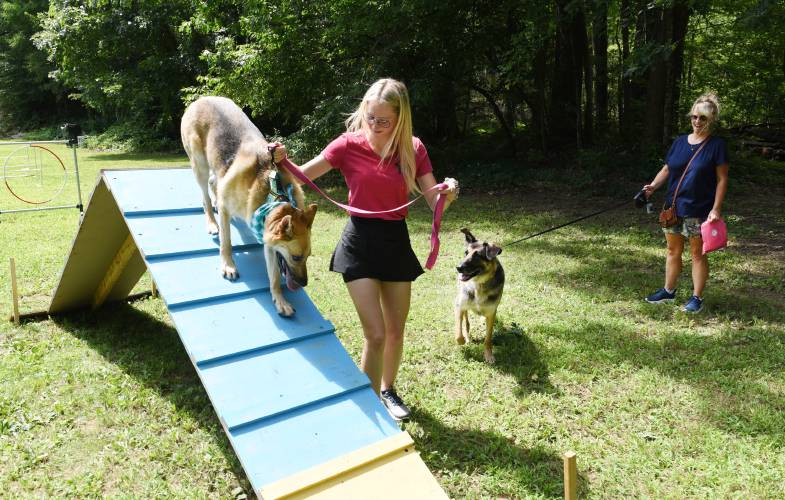 Madison Chmyzinski with Daisy and her mother Nicole Chmyzinski with Diesel, both from Montague, try out the agility course at the 2023 “Mutts in Need” fundraiser at the Millers Falls Rod & Gun Club. The event returns Saturday.