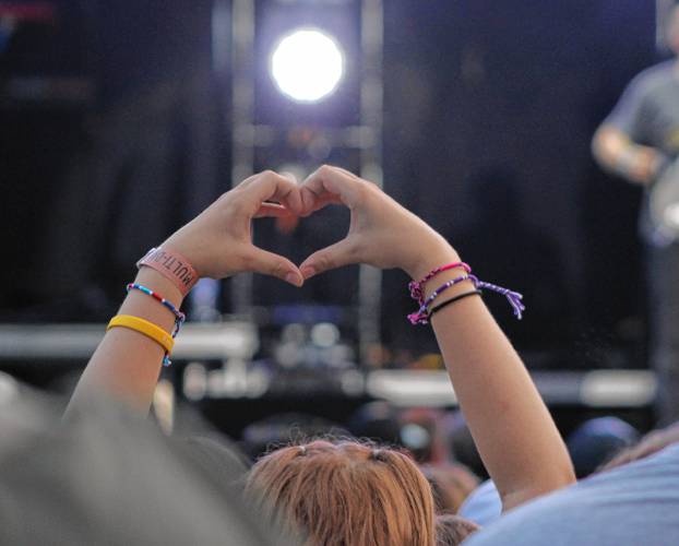 An attendee makes a heart sign during the We Are Messengers set during the SoulFest Christian music festival at the Franklin County Fairgrounds in Greenfield on Thursday.