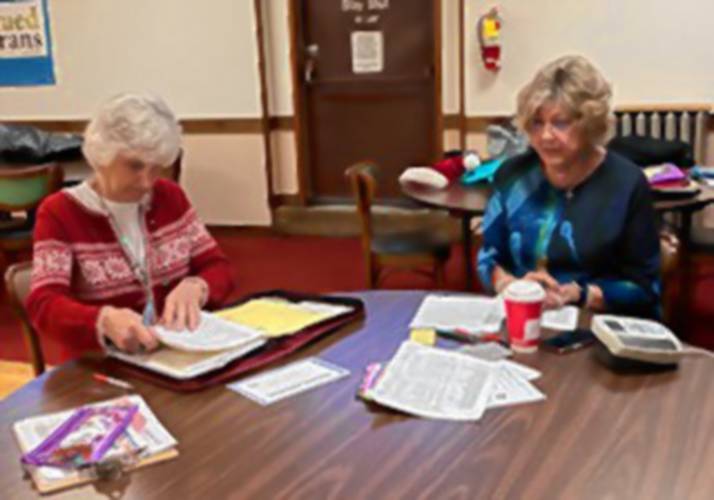 Kathy Porrovecchio and Adele Corcoran, weight recorders for Take Off Pounds Sensibly (TOPS), are busy at work tallying gains and losses.