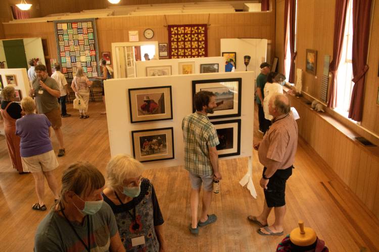 Artists and art enthusiasts peruse last year’s Heath Arts Exhibition.