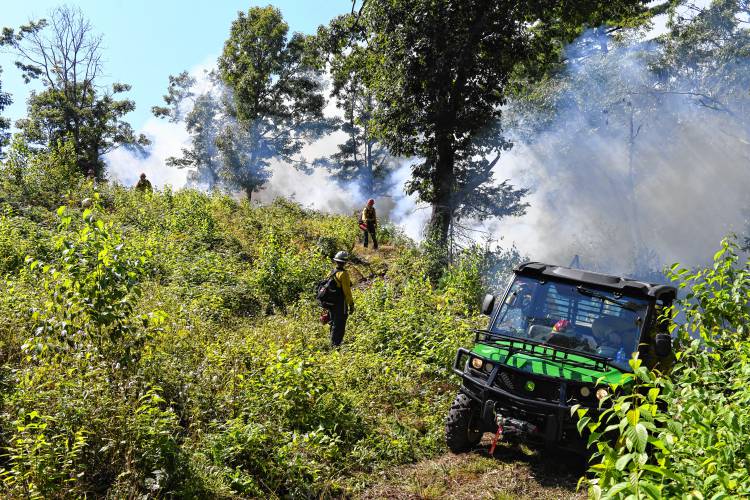 Personnel monitor a controlled burn in the Leyden Wildlife Management Area on Wednesday.