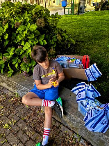 One of Meital Alloushillouz’s sons taking a break from distributing emblems of Israeli pride after the vigil began.