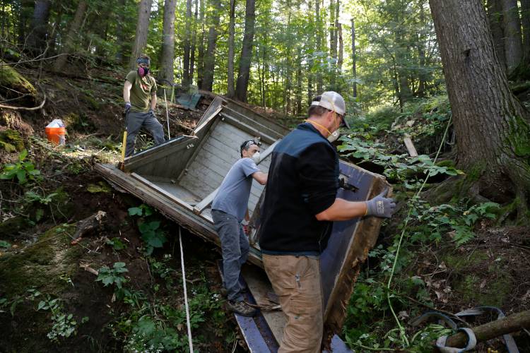 Volunteers from PV Squared, from left, Aric Lively Savage, Toby Moran and Craig Lakas, work to remove sections of an old collapsed building as part of the 2019 Source to Sea Cleanup along the Green River in Greenfield. The annual cleanup effort returns Sept. 28.