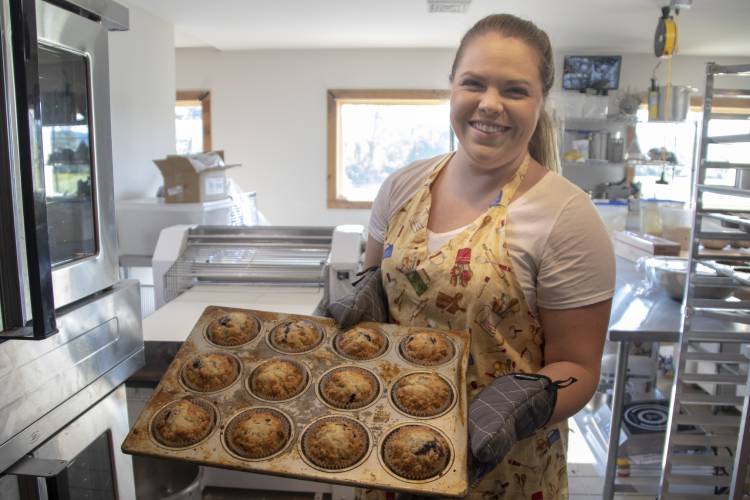 Laura Thiem, pictured here in 2018, pulls blueberry muffins out of the oven at Bittersweet Bakery & Cafe in Deerfield. The business, which marked its six-year anniversary at the end of August, is temporarily closed as Thiem evaluates a new five-year plan.