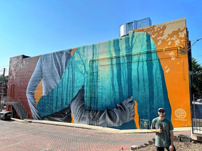 The completed mural on the side of the Shea Theater Arts Center on Avenue A in Turners Falls. Artist Darion Fleming (pictured) completed the mural early Monday morning, though a ribbon-cutting ceremony was held to celebrate on Saturday.