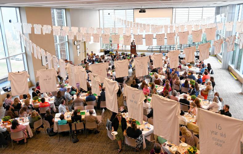 Children’s Advocacy Center of Franklin County and North Quabbin Executive Director Jeffrey Trant speaks at the annual Help, Hope and Healing Breakfast held at Greenfield Community College on Friday. The 158 T-shirts hanging from the ceiling represent the number of children the center has served over the past year.