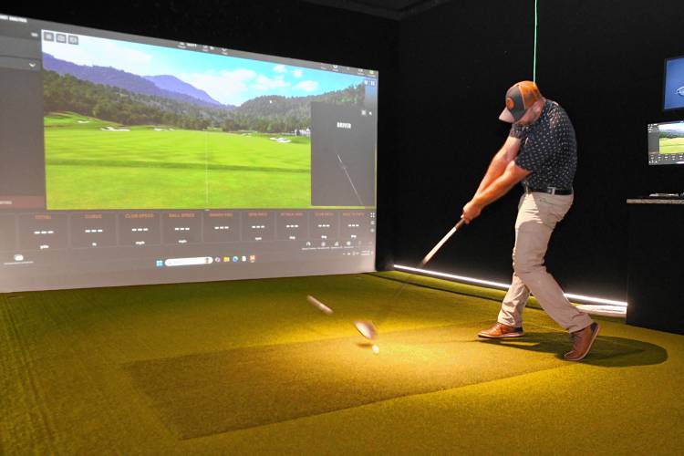 Matt Bardsley drives a ball at the simulator screen at the Birdie Train Golf Lounge located at the Boiler Bar & Grille in Orange.