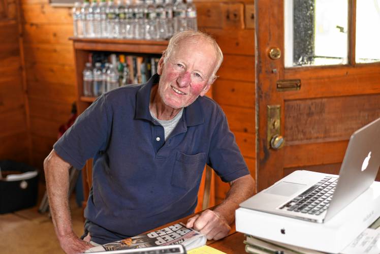 Chip Ainsworth sits at his desk in his Northfield home. Eight years ago he was diagnosed with prostate cancer and underwent treatment. Today, his levels “negligible,” his energy is good, and he walks seven miles a day.