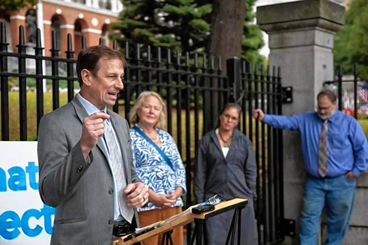 Toby Leary, left, who is chairing The Civil Rights Coalition working to repeal a gun law Gov. Maura Healey signed in July, speaks with reporters outside the State House on Sept. 19.