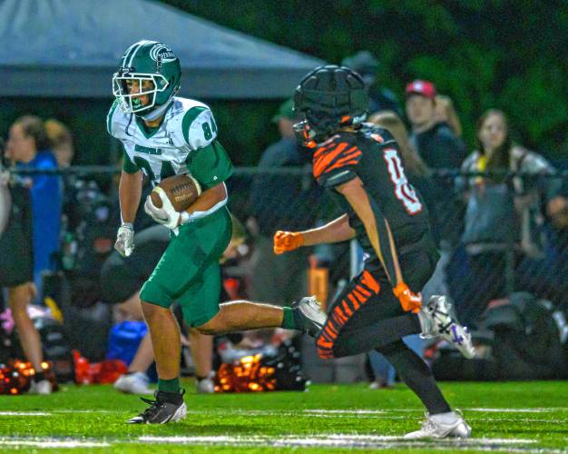 Greenfield’s Angel Politis, left, carries the ball past South Hadley’s Nehemiah Marrin during the first half of their high school football game at South Hadley on Friday.