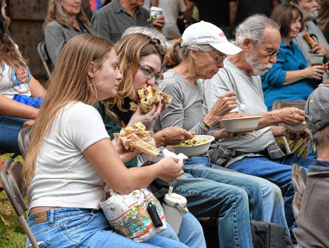 People enjoy the variety of food truck offerings while listening to Wallace Field play the family stage at the North Quabbin Garlic and Arts Festival in Orange on Sunday afternoon.