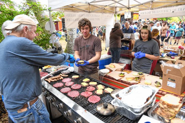 The kitchen crew at the Chase Hill Farm food booth keeps up with orders at the North Quabbin Garlic and Arts Festival in Orange on Sunday afternoon. 