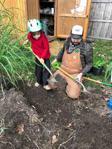 Ryan Nestor, the son and grandson of dedicated gardeners, shares the family passion to the next generation as he works with his son, Ollie, in their plot at the Pleasant Street Community Garden.