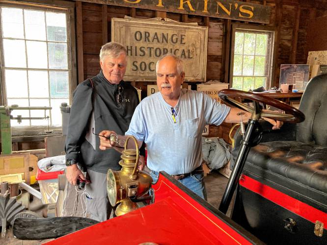 Orange Historical Society member Walter Pollard, right, gives Larry Grout Kennedy, of California, a personal viewing of one of the Grout Brothers automobiles in the Historical Society’s collection on Sept. 29. Kennedy is a great-great-grandson of Grout Brothers Automobile Co. industrialist patriarch William L. Grout. The pioneering auto manufacturer had been located on East Main Street, where Pete’s Tire Barn now operates.