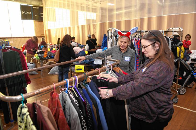 Volunteers Jean Barnhart, who is from Phoenix, Arizona, but is visiting relatives locally, and Susan Holmquist, of Vernon, Vermont, organize clothes at the free clothing store at Franklin County’s YMCA in Greenfield on Tuesday, where community members could browse and take donated new and used clothing, shoes and accessories.