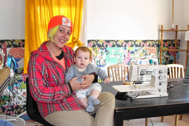 Kathryn Swanson, owner of Swanson’s Fabrics in Turners Falls, with her son Grover. Swanson’s Fabrics received $3,650 to develop mobile mending kits.